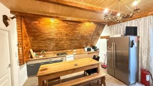 a kitchen with a refrigerator and a wooden wall at Cabanele Infinyti in Colibiţa