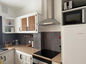 a kitchen with white cabinets and a stove top oven at Fajana de Trevejo in Garachico