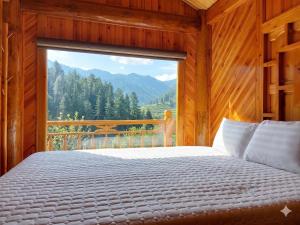 a bedroom with a bed and a large window at Sapa Rock Hill Homestay in Tả Van