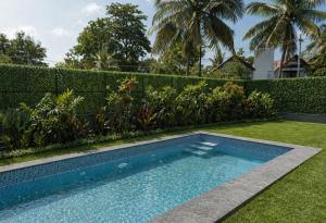 a swimming pool in the yard of a house at Rare Aura Villa in Dod Jāla