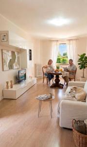 a man and a woman sitting at a table in a living room at Casa D&C in Avigliano