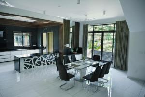 a kitchen and dining room with a table and chairs at Rare Aura Villa in Dod Jāla