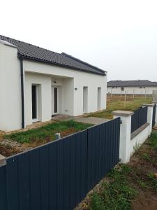 a house with a blue fence in front of it at Áporka vendégház in Áporka
