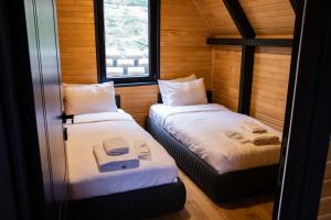 two beds in a small room with a window at Morrian Sapanca in Sapanca