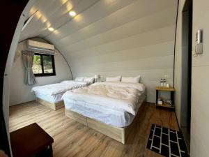 two beds in a room with an attic at 歐森View包棟Villa x 雲海夜景 x 獨立空間 in Dongshi