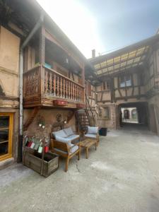a house with a balcony and a table and chairs at Chez Mamema in Barr