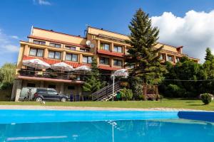 a building with a swimming pool in front of a building at Ośrodek Wypoczynkowy Niagara in Międzybrodzie Żywieckie