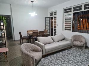 a living room with a couch and chairs and a table at Beach Hostel do Japa in Ubatuba +1 photo