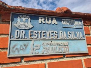 a sign on the side of a brick wall at Beach Hostel do Japa in Ubatuba