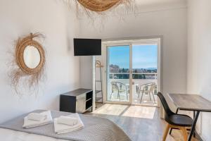 ein Schlafzimmer mit Bett, Tisch und Balkon in der Unterkunft Hôtel Paradis in Bormes-les-Mimosas