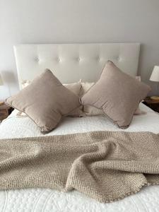 a bed with two pillows and a blanket on it at Nova Studio Dpto nuevo a pasos de Av Alemania in Temuco