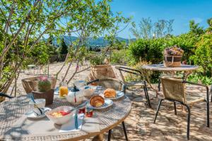 ein Tisch mit Frühstücksessen auf einer Terrasse in der Unterkunft Hôtel Paradis in Bormes-les-Mimosas