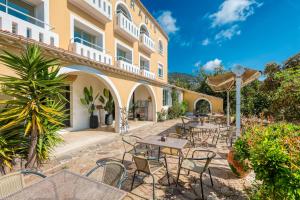 eine Terrasse mit Tischen und Stühlen vor einem Gebäude in der Unterkunft Hôtel Paradis in Bormes-les-Mimosas
