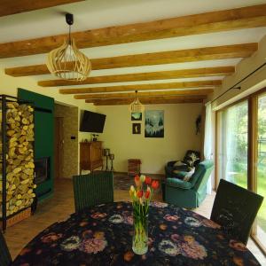 a dining room with a table with a vase of flowers at Domek na wynajem Lgiń in Wschowa