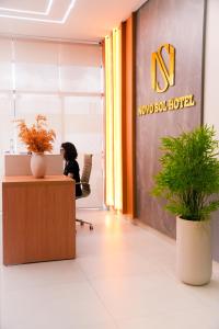 a woman sitting at a desk in an office at Hotel Novo Sol in Petrolina