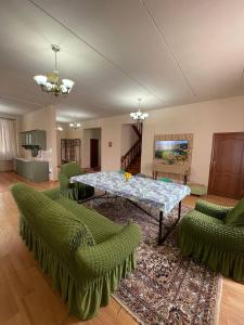 a living room with a table and green chairs at Wings Ethno in Cholpon-Ata