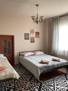 a bedroom with two beds and a chandelier at Wings Ethno in Cholpon-Ata
