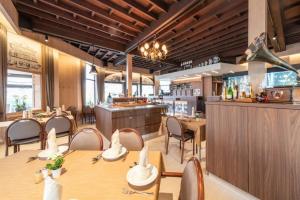 a restaurant with tables and chairs and a bar at Familiehotel Soll Cress Koksijde in Koksijde