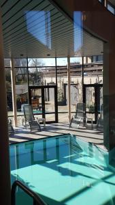 a swimming pool with four chairs and a building at Familiehotel Soll Cress Koksijde in Koksijde