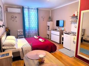 a room with a bed and a table and a kitchen at Guest House Barocco in Rovinj