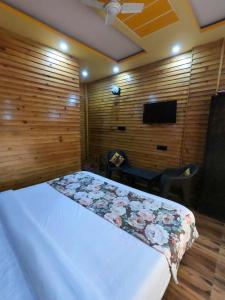 a bedroom with a bed in a room with wooden walls at Bagwan Kainchi Stay in Bhowāli