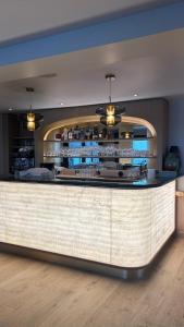 a bar in a restaurant with a counter at Hotel Restaurant Les Venetes in Arradon