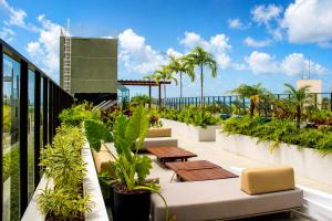 a balcony with tables and plants on a building at Jardins Almare Apart Hotel in João Pessoa