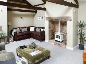 a living room with a couch and a fireplace at Cloggy Nook Tughall in Swinhoe