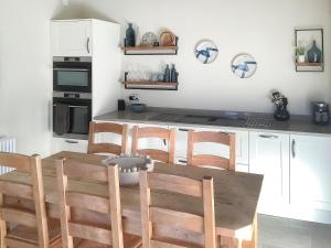 a kitchen with a wooden table and some chairs at Cloggy Nook Tughall in Swinhoe