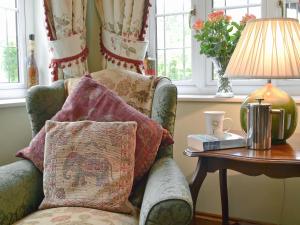 a living room with a chair and a table with a lamp at The Appleloft in Westleigh