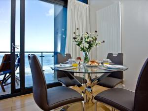 a dining room with a table with a vase of flowers at Bliss - Horizon View in Westward Ho