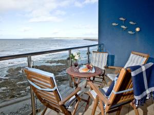 a balcony with a table and chairs and the ocean at Bliss - Horizon View in Westward Ho