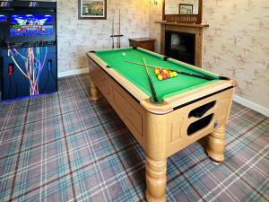 a pool table in a room with a video game at Drummuie House in Golspie +16 photos