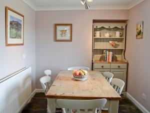 a dining room table with a bowl of fruit on it at Drummuie House in Golspie