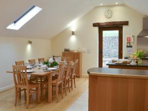 a kitchen and dining room with a table and chairs at Tythe Barn in Froggatt