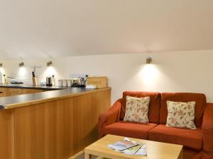 a living room with a couch and a kitchen at Tythe Barn in Froggatt +14 photos