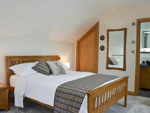 a bedroom with a large white bed and a mirror at Bluebell Barn in Okehampton +7 photos