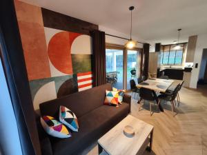 a living room with a couch and a table at Kropla Rosy 27 in Orchówek