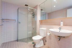 a bathroom with a shower and a toilet and a sink at Glenelg Holiday Apartments-Pier in Adelaide