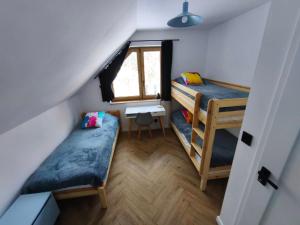 a small room with two bunk beds and a window at Kropla Rosy 27 in Orchówek