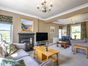 a living room with a fireplace and a tv at Mount Pleasant in Threlkeld