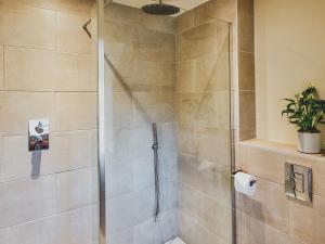 a shower stall with a glass door in a bathroom at Mallard Cottage in Winchester