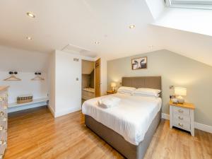 a bedroom with a large white bed and wooden floors at Ty Godro - Uk12745 in Acrefair