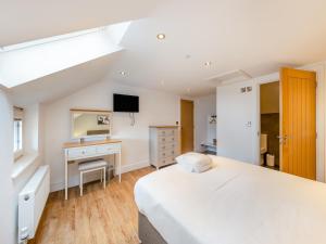 a white bedroom with a bed and a desk at Ty Godro - Uk12745 in Acrefair