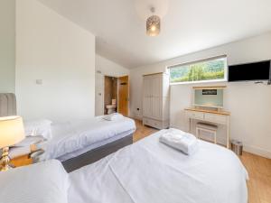 a bedroom with two beds and a television in it at Ty Godro - Uk12745 in Acrefair +19 photos