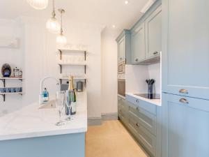 a kitchen with white cabinets and a sink at Eagles Nest At Greyfriars - Uk33356 in Winchelsea +18 photos