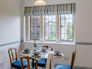 a dining room with a table and chairs and windows at Eagles Nest At Greyfriars - Uk33356 in Winchelsea