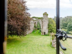 a window view of an old stone building in a field at Eagles Nest At Greyfriars - Uk33356 in Winchelsea