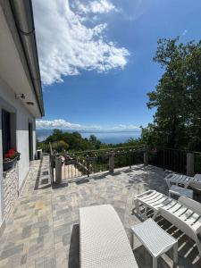 a patio with chairs and tables on a balcony at Apartman SÙŠANJ in Opatija