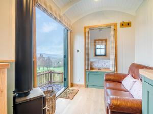 a living room with a couch and a large window at Hut Uk42176 in Usk